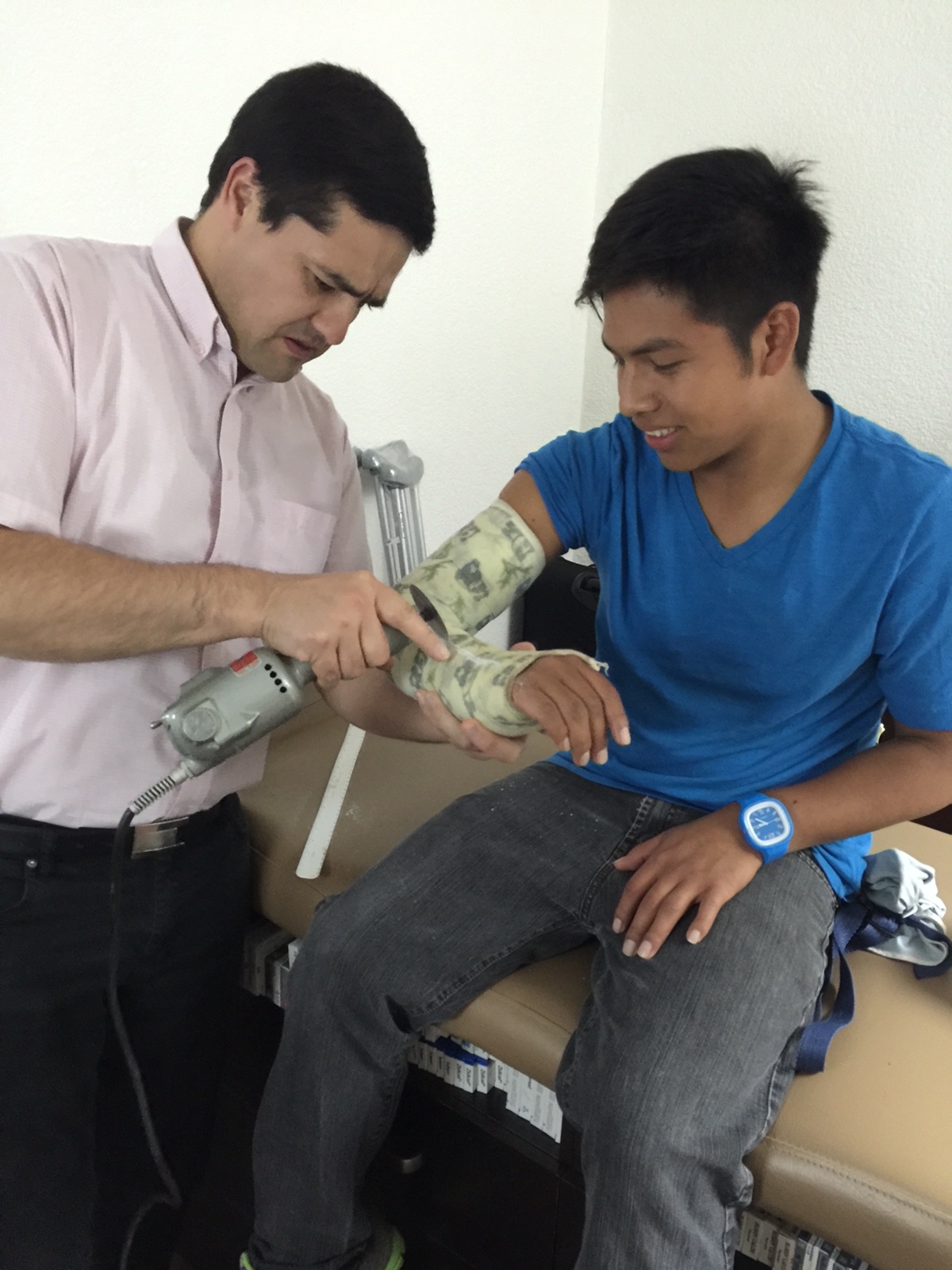 Dr Miguel taking off Bryan's cast
