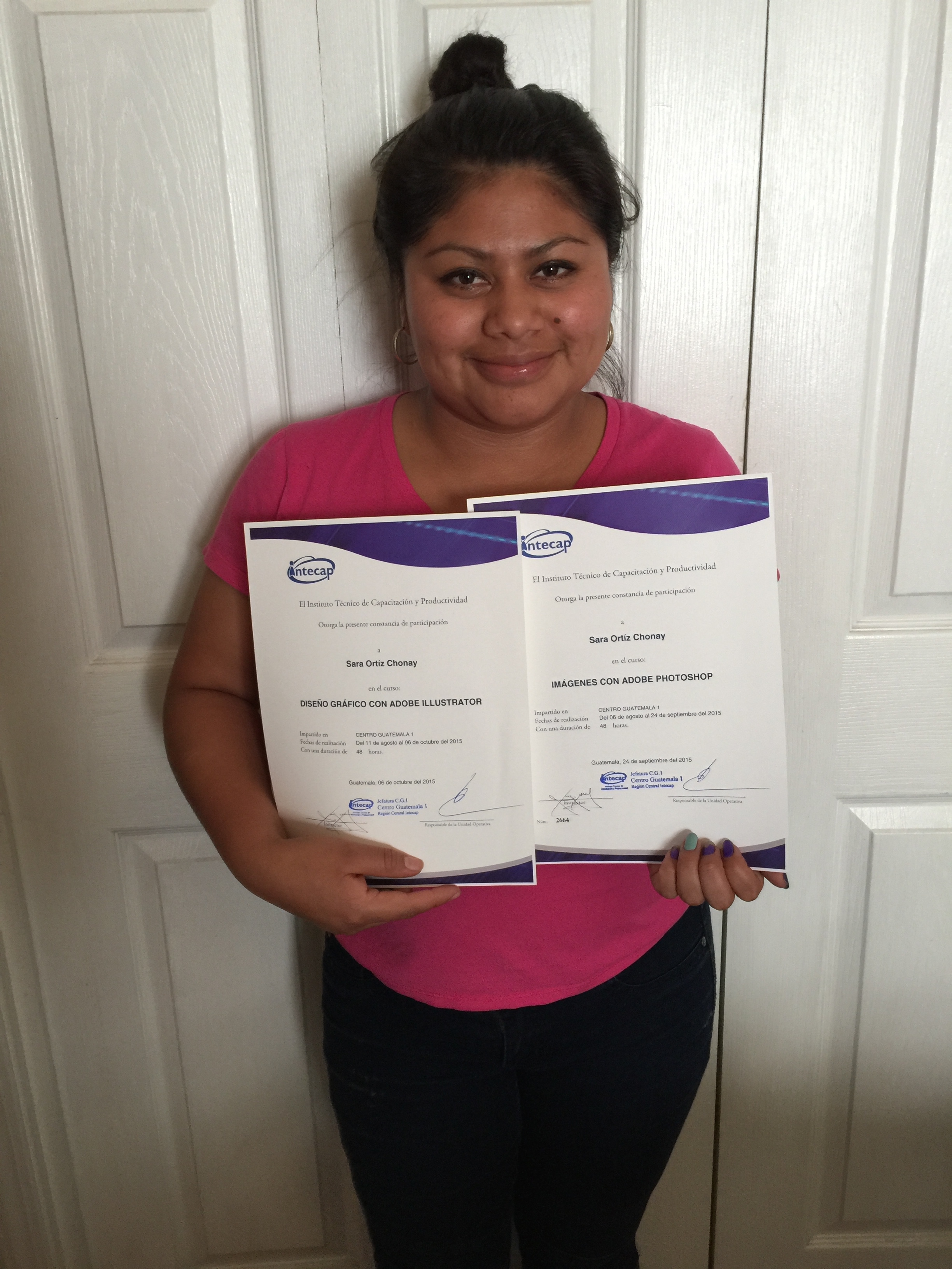 Sarah with her two diplomas in computer and phot shop